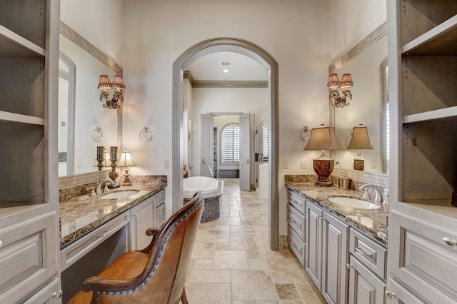 bathroom featuring crown molding, vanity, and a tub