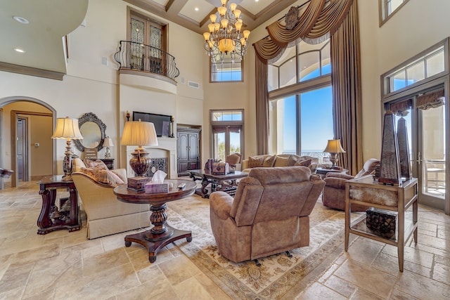 living room featuring crown molding, a high ceiling, and a chandelier