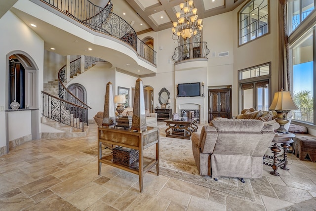 living room featuring beamed ceiling, a chandelier, and a high ceiling