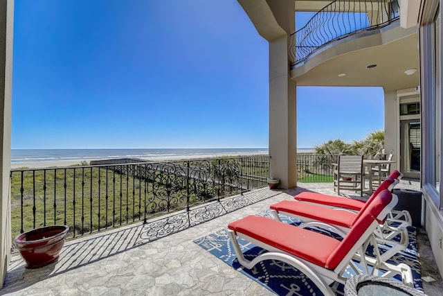 balcony featuring a water view and a view of the beach