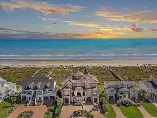 aerial view at dusk featuring a water view