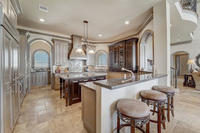 kitchen featuring a healthy amount of sunlight, a kitchen bar, and a kitchen island