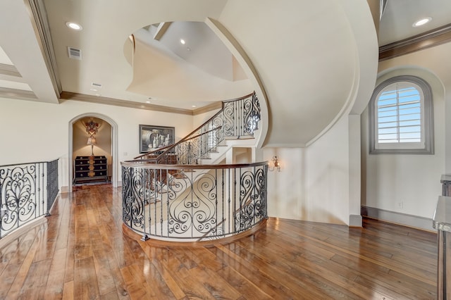 interior space featuring wood-type flooring, beamed ceiling, and crown molding