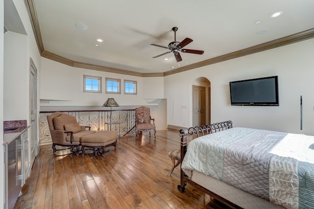 bedroom featuring wood-type flooring, ornamental molding, and ceiling fan