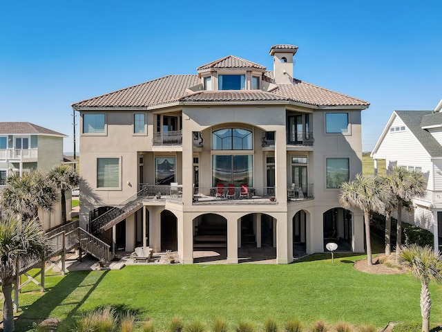 rear view of house featuring a balcony, a patio area, and a yard