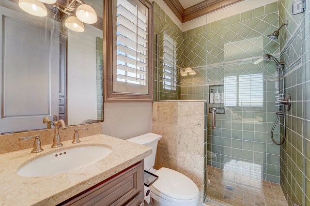 bathroom with ornamental molding, vanity, toilet, and an enclosed shower