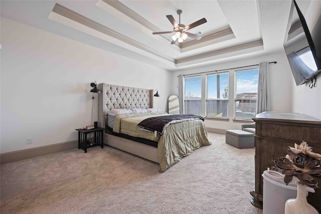 carpeted bedroom with ceiling fan, a raised ceiling, and crown molding