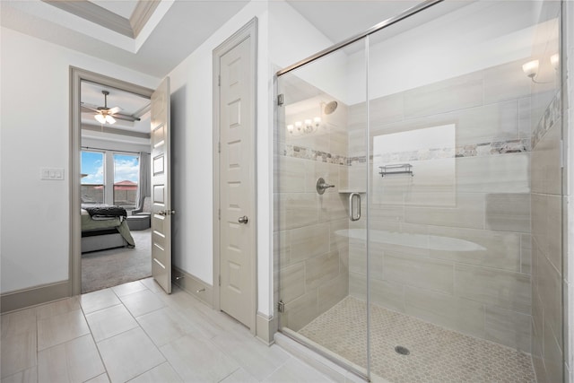 bathroom with tile patterned flooring, an enclosed shower, a tray ceiling, and ceiling fan