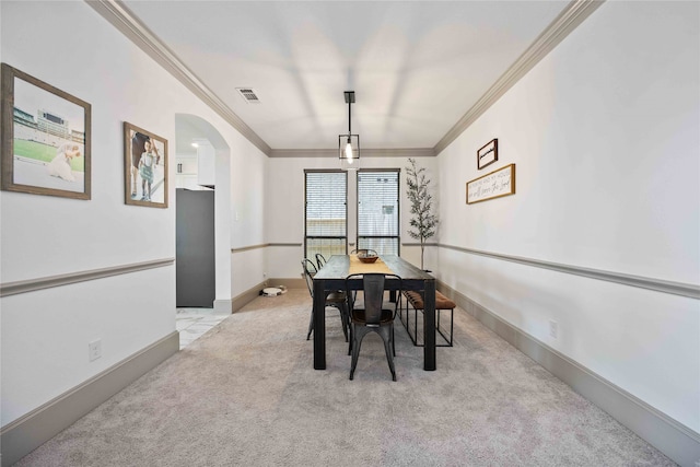 carpeted dining space featuring crown molding