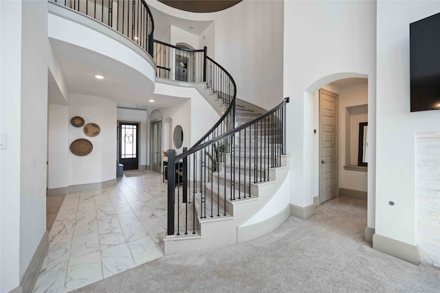 entryway with a high ceiling and light carpet