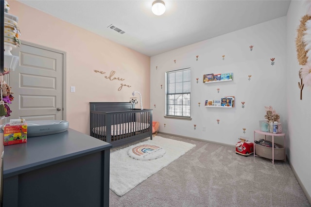 bedroom featuring a nursery area and carpet flooring