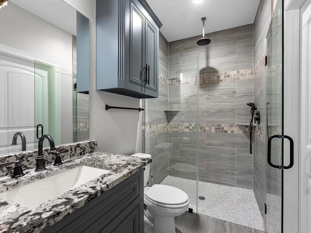 bathroom with vanity, toilet, and an enclosed shower