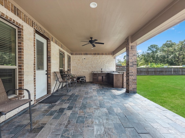 view of patio with sink, ceiling fan, and exterior kitchen