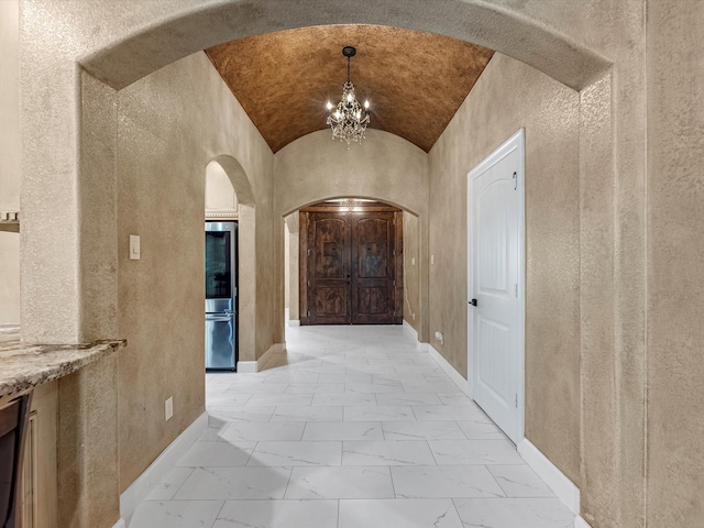 corridor featuring lofted ceiling and a chandelier