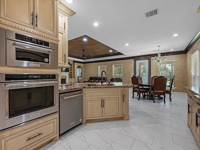 kitchen with hanging light fixtures, sink, a chandelier, dark stone countertops, and stainless steel double oven