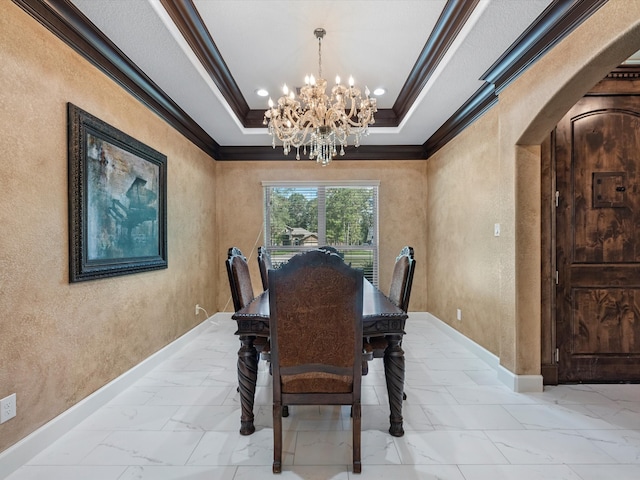 dining room featuring ornamental molding, a notable chandelier, and a raised ceiling