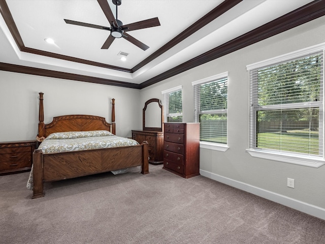 bedroom featuring ceiling fan, light colored carpet, a raised ceiling, and crown molding