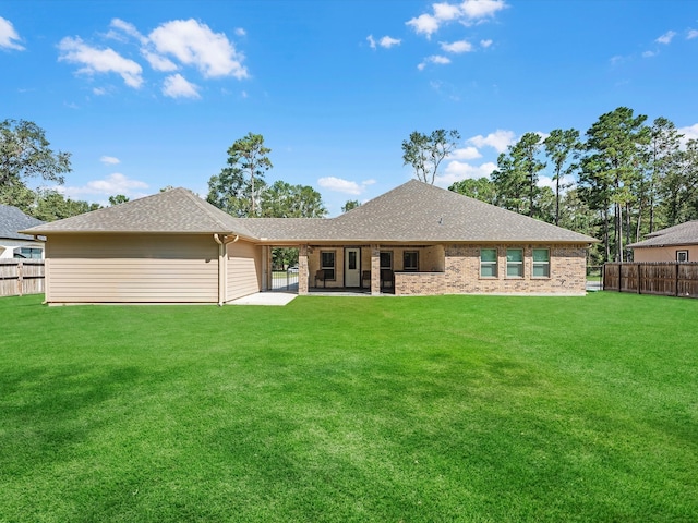 rear view of house with a patio and a yard