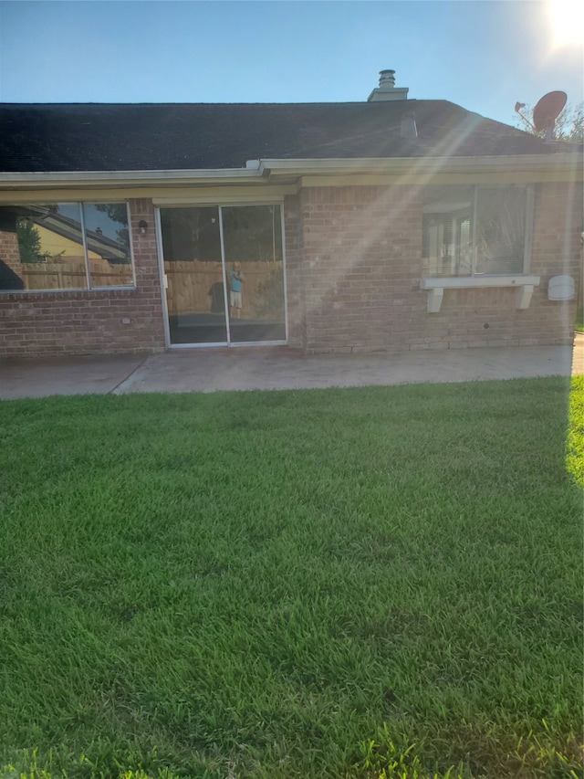 back of house with a lawn and a patio area