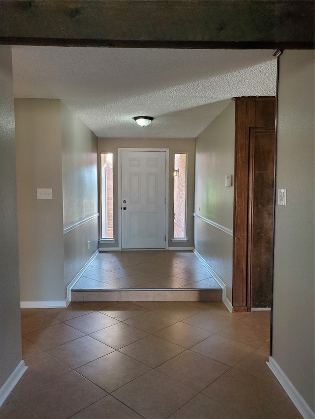 tiled foyer featuring a textured ceiling