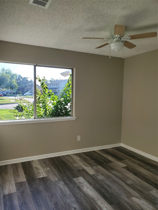 empty room featuring a textured ceiling, dark hardwood / wood-style flooring, and ceiling fan