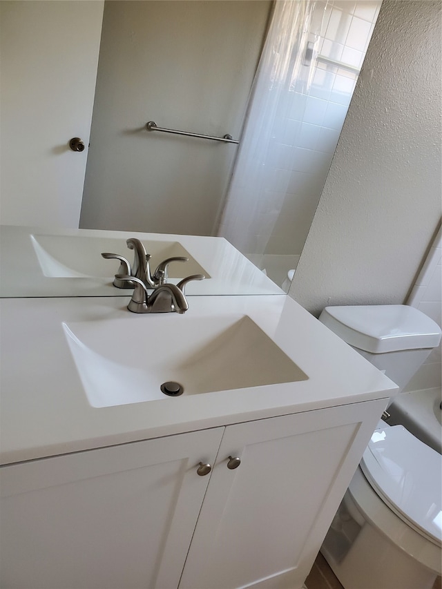 bathroom featuring walk in shower, vanity, and toilet