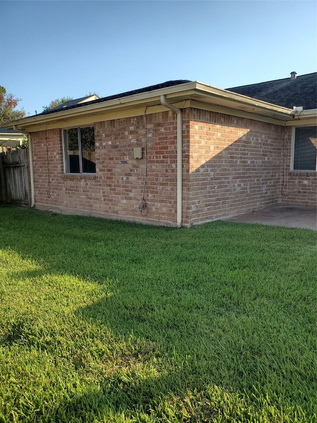 view of property exterior featuring a lawn and a patio area