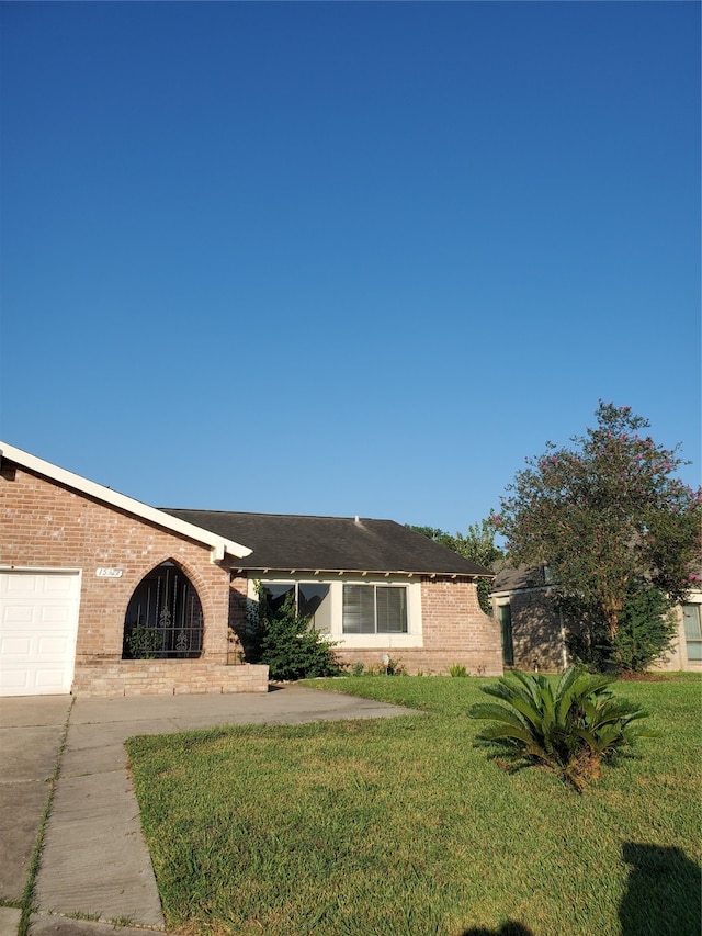 ranch-style house with a garage and a front lawn