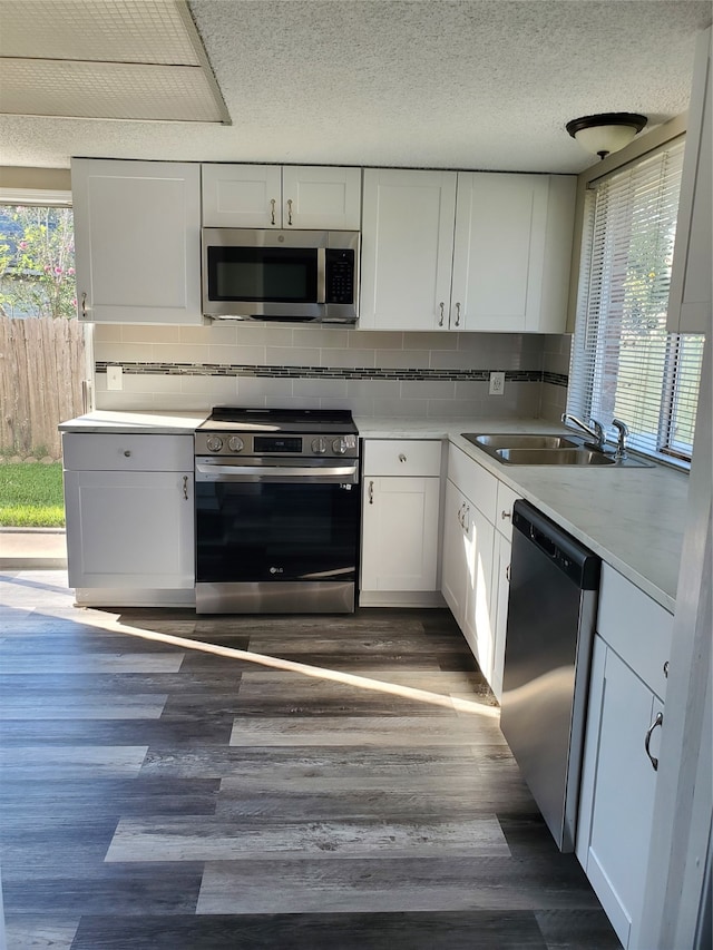 kitchen featuring stainless steel appliances, white cabinetry, and a wealth of natural light