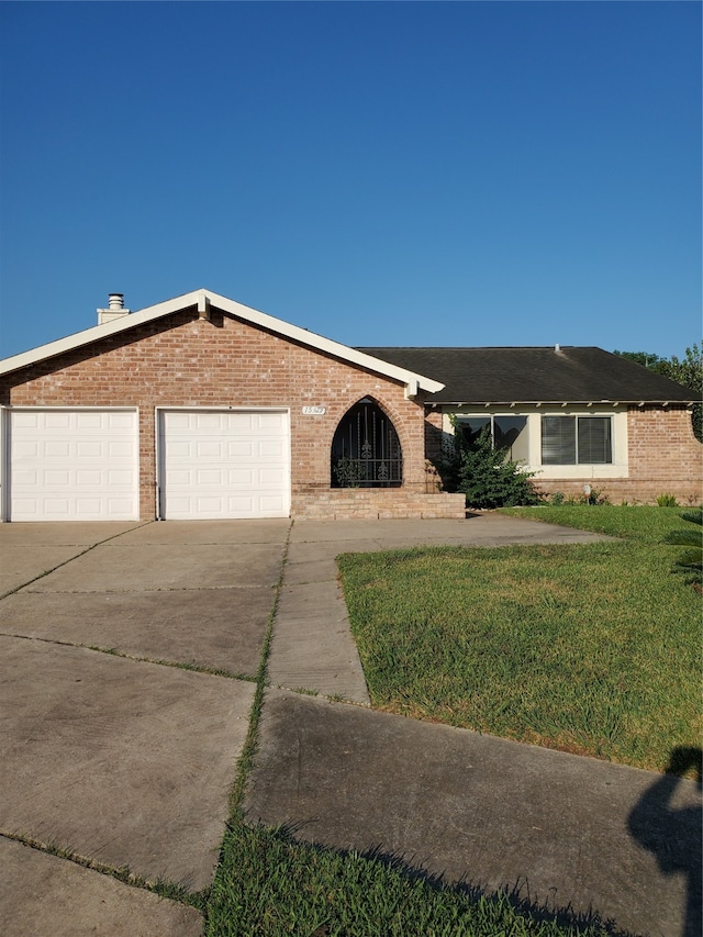 ranch-style home with a garage and a front lawn