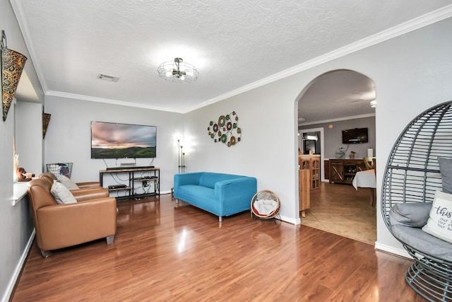 5522 Cannonway Dr, Houston, TX 77032 - living room with a textured ceiling, visible vents, crown molding, arched walkways, and wood finished floors