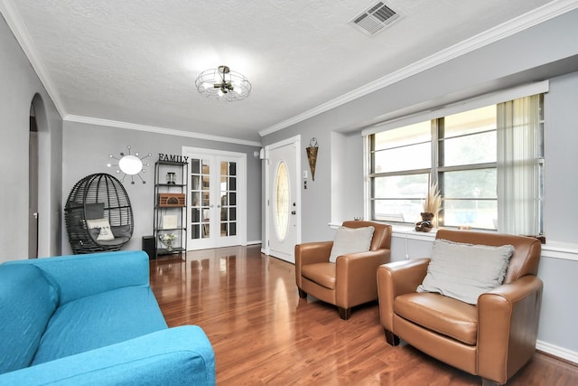 living room featuring a textured ceiling, dark hardwood / wood-style floors, and ornamental molding