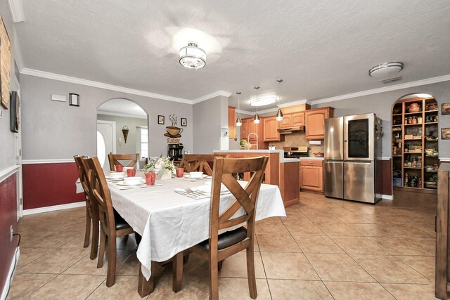 5522 Cannonway Dr, Houston, TX 77032 - dining space featuring arched walkways, a textured ceiling, light tile patterned floors, and ornamental molding