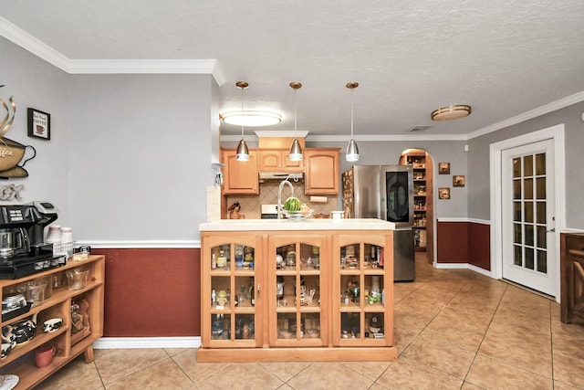 5522 Cannonway Dr, Houston, TX 77032 - kitchen with freestanding refrigerator, glass insert cabinets, light countertops, under cabinet range hood, and arched walkways
