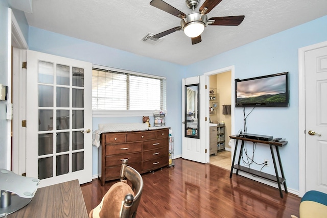 living area featuring ceiling fan, a textured ceiling, and dark hardwood / wood-style floors