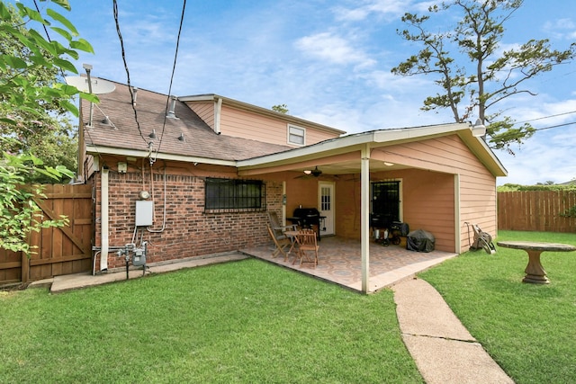 back of property featuring a yard, ceiling fan, and a patio area