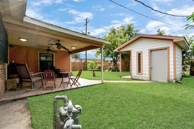 view of yard with ceiling fan, a storage unit, and a patio area