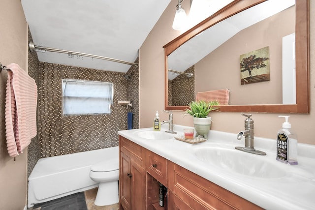 full bathroom featuring tiled shower / bath, vanity, lofted ceiling, and toilet