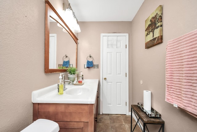 bathroom featuring tile patterned floors, vanity, and toilet