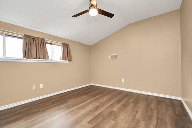 empty room featuring wood-type flooring, lofted ceiling, ceiling fan, and a textured ceiling