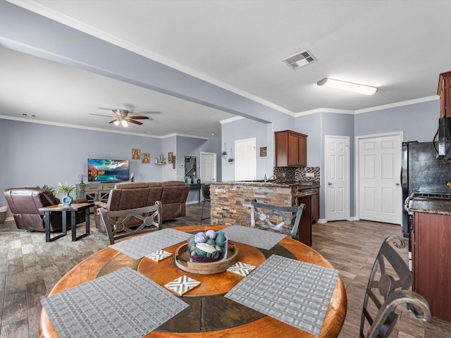 dining room featuring ornamental molding, ceiling fan, and hardwood / wood-style flooring