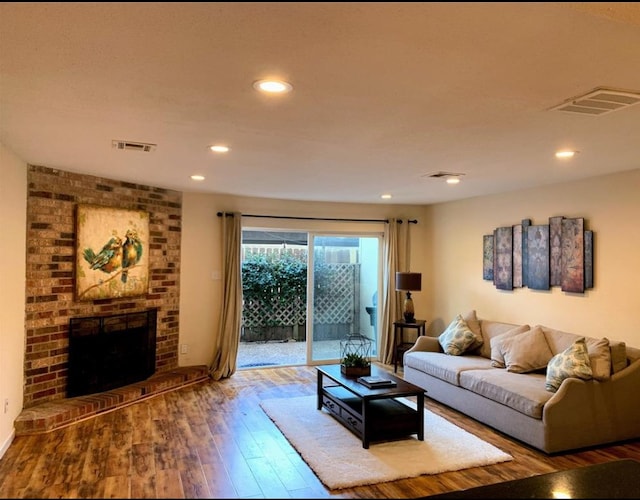 living room with wood-type flooring and a fireplace