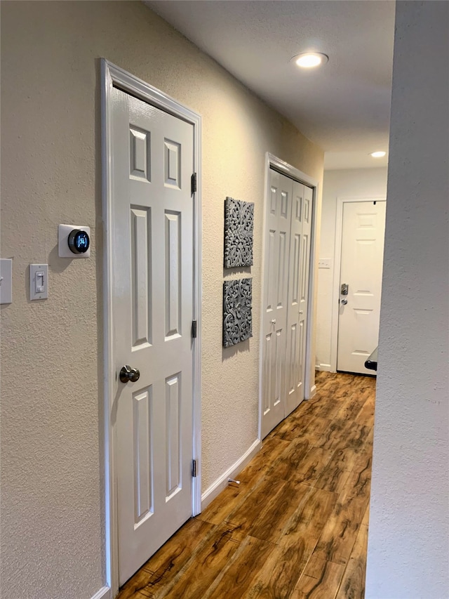 corridor with dark hardwood / wood-style flooring