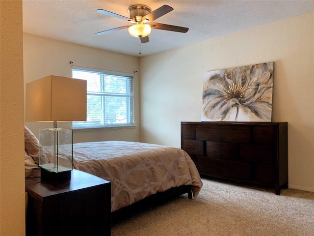 carpeted bedroom featuring a textured ceiling and ceiling fan