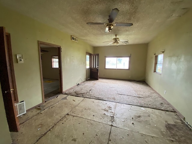 unfurnished room featuring ceiling fan and a textured ceiling