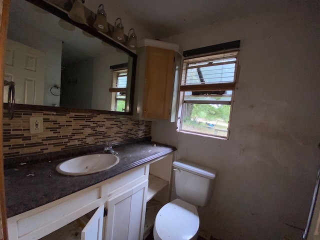 bathroom with decorative backsplash, vanity, and toilet