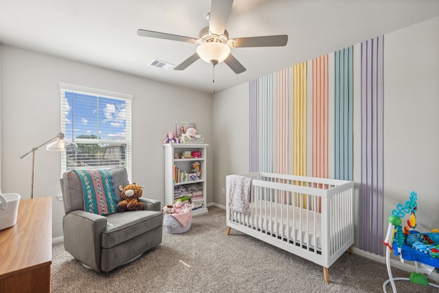 bedroom with a crib, carpet, and ceiling fan