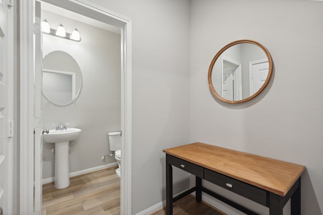 bathroom featuring toilet, wood-type flooring, and sink