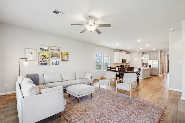 living room featuring ceiling fan and light wood-type flooring