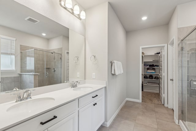 bathroom featuring tile patterned flooring, vanity, and walk in shower